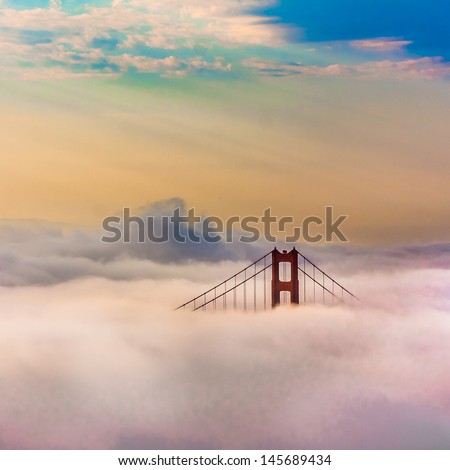 World Famous Golden Gate Bridge Surrounded by Fog after Sunrise in San Francisco,California