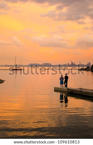 People fishing by the lake as the sun sets
