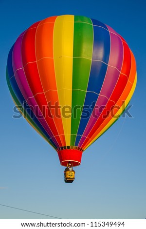 Colorful hot air balloons float up in the blue sky