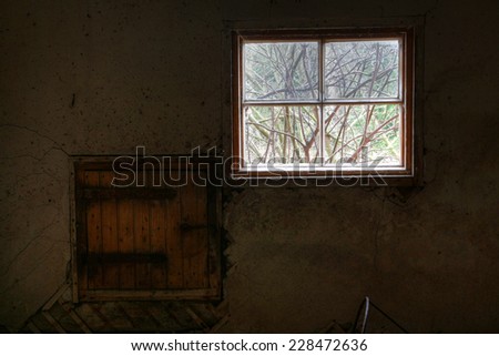 Urban exploration. View from abandoned farm\'s cowshed.