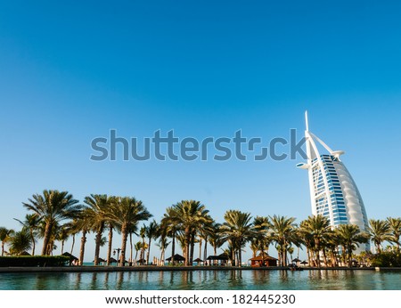 DUBAI, UNITED ARAB EMIRATES - DECEMBER, 10, 2013 : Beach with palms and view on seven stars luxury hotel Burj Al Arab \