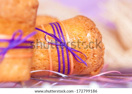 muffin with purple ribbon on purple background. food
