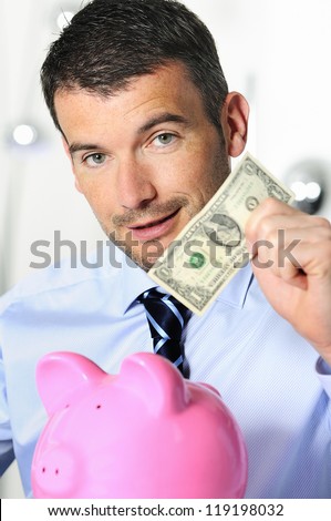businessman matting a coin in the piggy-shaped pink pig
