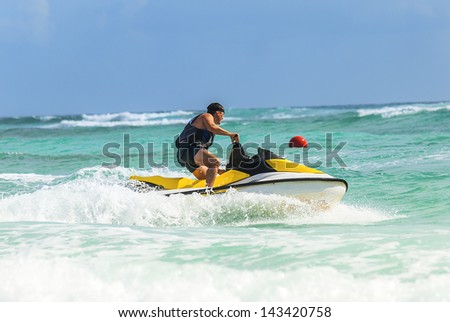 Man on Wave Runner turns fast on the water