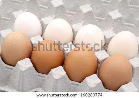 The brown and white eggs in egg box