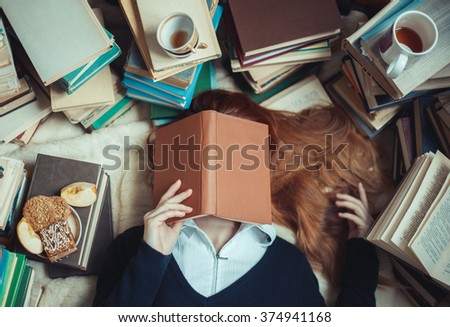 Girl sleeping near  books with and cups of tea