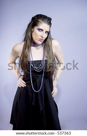 Attractive young woman wearing painted pearl necklaces with matching eye makeup looking fierce