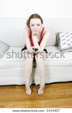Young woman with TV remote looking forward