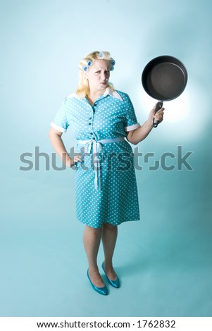 Blond woman with curlers in her hair and frying pan