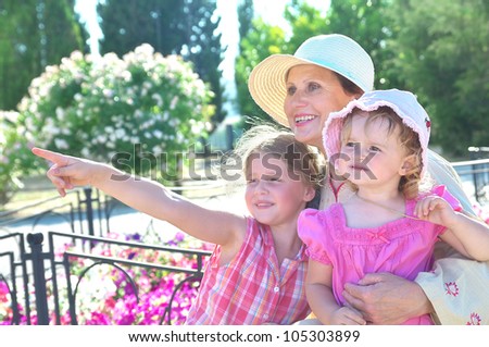 Grandma and her two granddaughters have a rest in the park