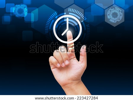Hand pressing clock button on technology background