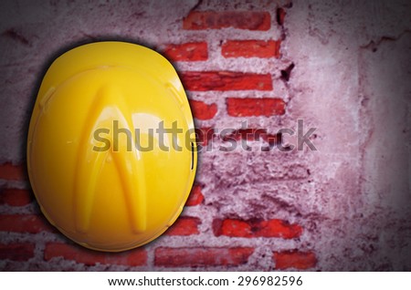 Safety helmet hanging on an old brick wall