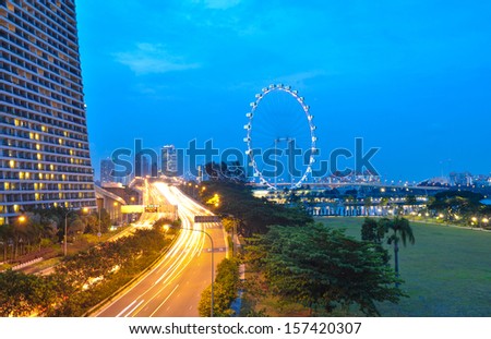 SINGAPORE - AUGUST 26: Singapore Flyer and night road on August 21, 2013 in Singapore. Singapore Flyer is the tallest Ferris wheel in the world.