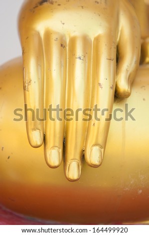 Closed up hand of gold buddha in temple