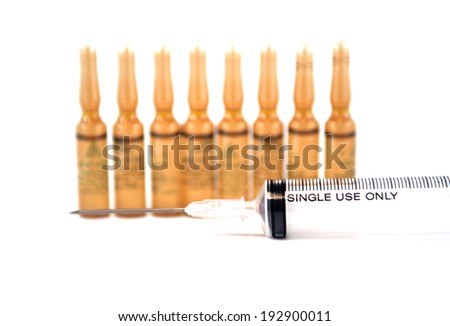 Disposable syringe and brown injection ampule background