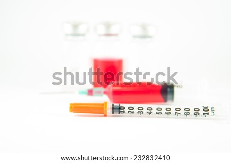 Disposable syringe and red liquid in injection vial