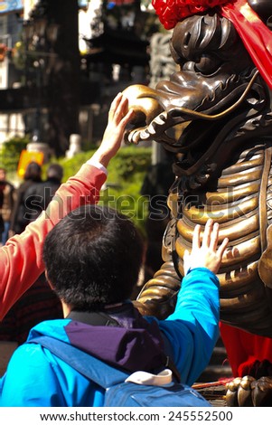 HONG KONG - January 19, 2015 -Tourist visit the Wong Tai Sin Buddhist Temple to touch nose of steel lion on January 19, 2015, in Hong Kong.