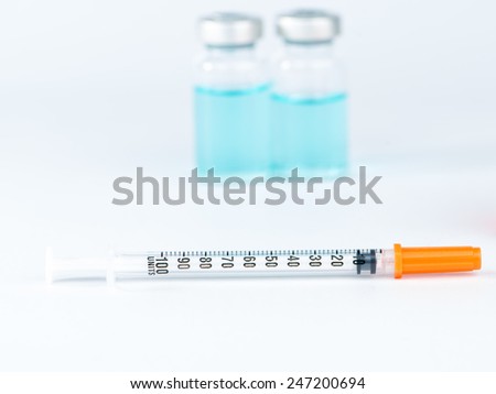 Disposable syringe and blue liquid in  injection vials background
