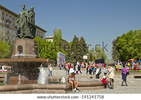 VOLGOGRAD - MAY 4:Participant of the Volgograd marathon takes  plate number with t-shirts sitting at the fountain of Arts.  May 4, 2014 in Volgograd, Russia.