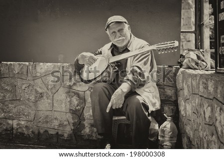 ANTALYA, TURKEY - MAY 14:Old street musician with a guitar in hand asking for money from tourists . May 14, 2014 in Antalya, Turkey.