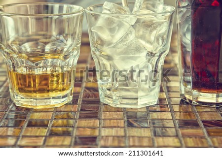 Glasses with drinks on the table in the cafe. Whiskey, ice and Cola