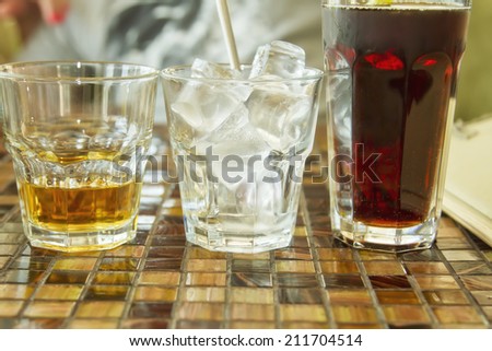 Glasses with drinks on the table in the cafÃ?Â©. Whiskey, ice and Cola