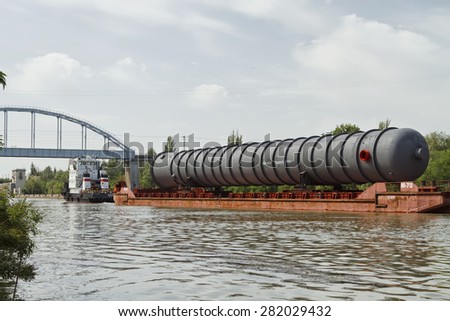 VOLGOGRAD - MAY 27: An oversized part of the column for the petrochemical industry on a barge on the Volga-don shipping canal. May 27, 2015 in Volgograd, Russia.