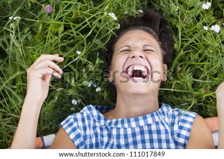 laughing girl lying on a lawn - rolling on the floor laughing