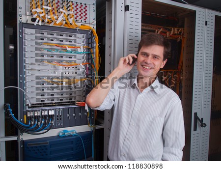 Network engineer in server room talking on the mobile phone