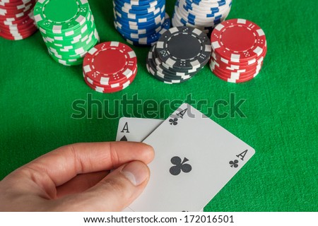 win - two Aces and poker chips stack on green table