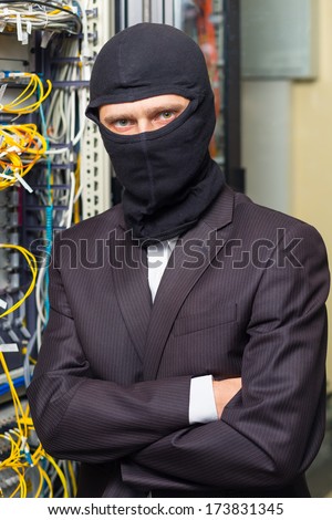 robber in black mask in the server room hack, and steals information, unauthorized downloading data