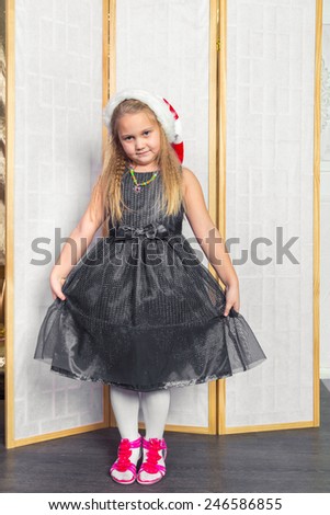 Little girl with white hair in a gray dress red shoes posing standing