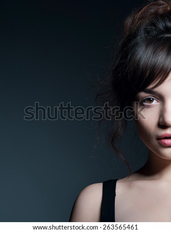 Young beautiful woman with natural makeup looking at camera. Over gray background