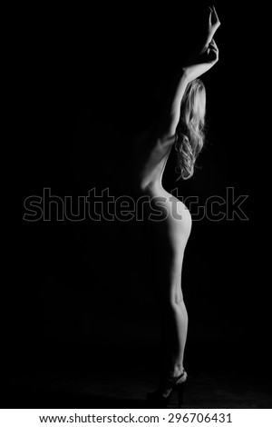black and white photograph of a silhouette of a girl on a black background. the curves of the female body