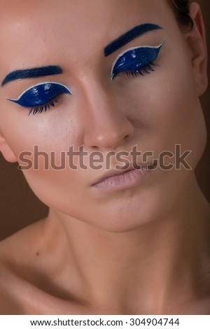 art photo art of makeup girl with brightly highlighted cheekbones. Makeup dark blue eyes