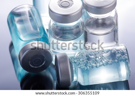 Photo medical vials for storage of medicines on a black mirrored background with bright reflections. Pills.