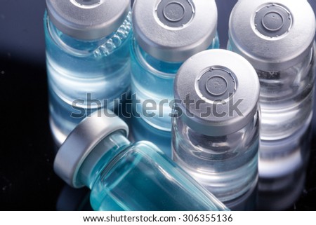 Photo medical vials for storage of medicines on a black mirrored background with bright reflections. Pills.