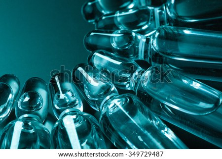 Photo medical ampoules on a dark background in blue-green tinting