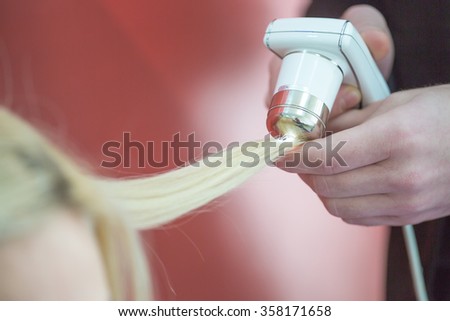 hair treatment. hair testing. man\'s hand with the device for testing fiber optic links