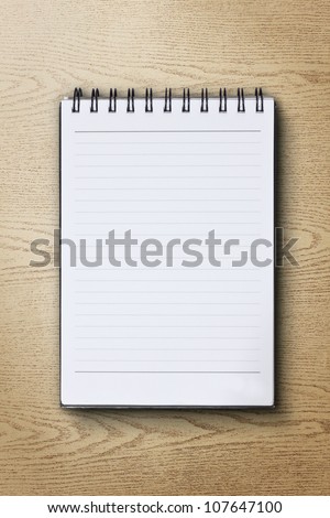 single face notebook on wood background