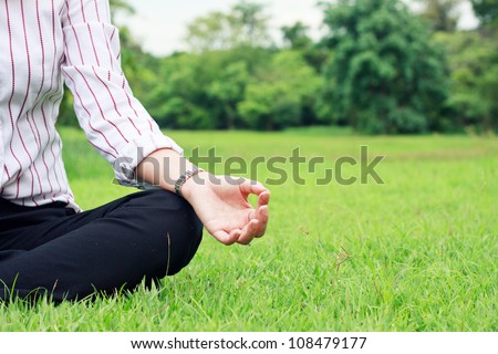 A business woman relax in a park in the lotus position in close-up