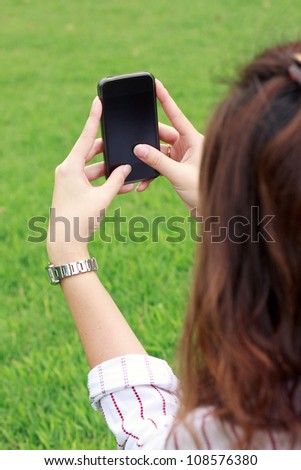 Business woman using mobile smart phone in the park