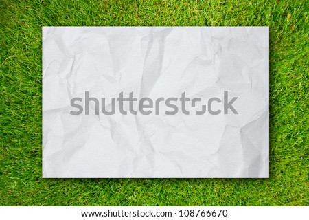 White Crumpled paper on Green grass background