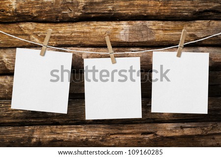 three  paper attach to rope with clothes pins on old wooden background