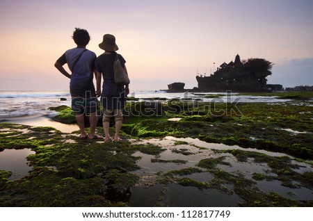 silhouette Couple people in Tanah Lot and sea waves in sunset, on Bali island Indonesia