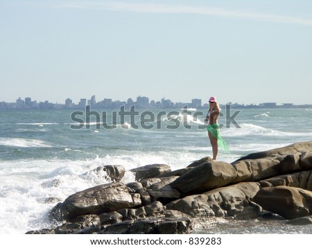 Girl on the rocks with hazy city (Durban) in background