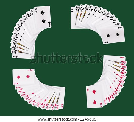 Full deck of playing cards spread by suit on green card table