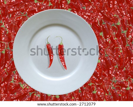 A hot meal - red hot chilies on a plate on a bed of chillies
