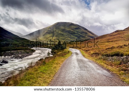 A stream tumbles along in tandem with the road to Glen Coe.  Glen Coe is a glen in the Highlands of Scotland.  It is often considered one of the most spectacular and beautiful places in Scotland,