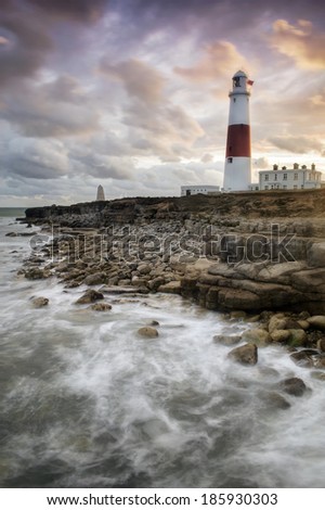 Portland Bill Lighthouse stands sentinel on the rugged south England coast as the suns last rays illuminate the impressive structure.